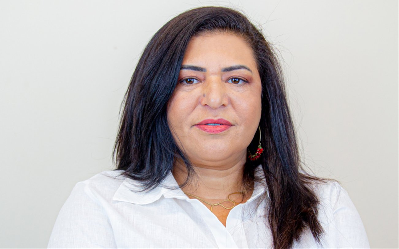 Imagem de Neiva Ribeiro. Ela é uma mulher branca de cabelos negros e lisos