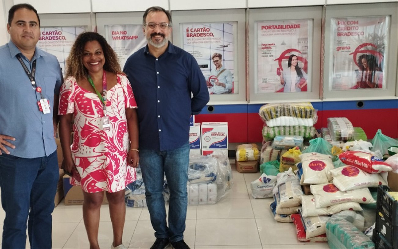 Os dirigentes Welington Corrêa, Alexandre Bertazzo e Sandra Regina ao lado de parte das quase duas toneladas de alimentos doados pelos bancários do Bradesco Os dirigentes Welington Corrêa, Alexandre Bertazzo e Sandra Regina ao lado das quase duas toneladas de alimentos doados pelos bancários do Bradesco