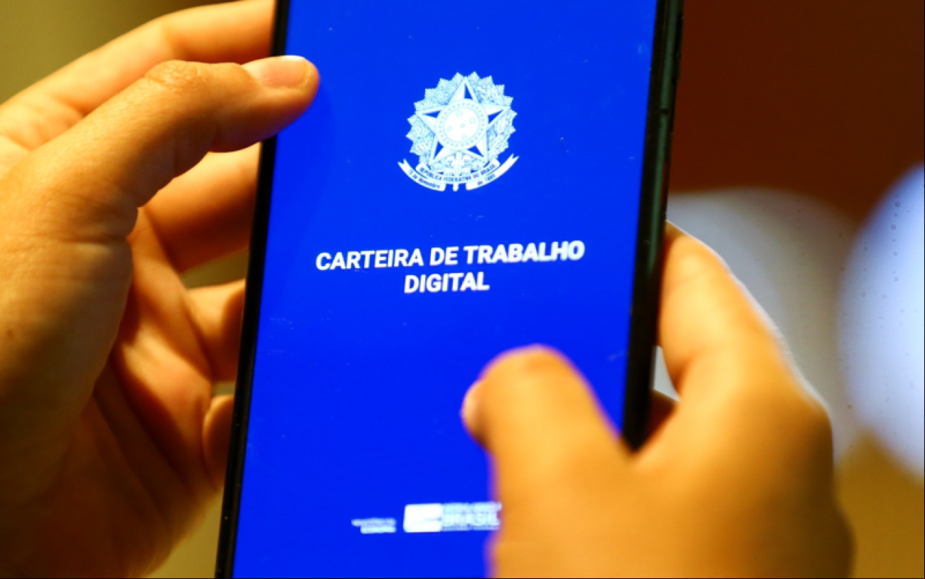 Foto: Marcelo Camargo/Agência Brasil Imagem mostra uma pessoa mexendo em um celular com o aplicativo da carteira de trabalho digital aberta na tela do aparelho