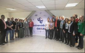 Imagem mostra membros da Comissão Executiva dos Empregados da Caixa e integrantes da direção do banco durante visita à Universidade Caixa. 