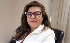 Neiva Ribeiro, presidenta do Sindicato dos Bancários, veste um blazer branco e usa óculos