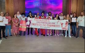 Imagem mostra dirigentes e funcionários do Sindicato dos Bancários de São Paulo durante mais uma etapa da campanha para denunciar a reestruturação em curso no Bradesco. Eles estão perfilados no saguão do Bradesco International Plaza e portam uma faixa onde se lê "Fortalecer a orgaização em defesa do emprego"