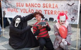 Dia Nacional de Luta levou para as ruas o terror que os banqueiros fazem na vida dos bancários. Na foto, os personagens pânico, fred e it possam em frente a uma faixa com os dizeres "seu banco seria qual vilão do terror