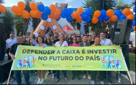 Imagem mostra bancários atrás de uma faixa onde se lê  'Defender a Caixa é investir no futuro do país'