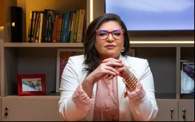 Neiva Ribeiro, presidenta do Sindicato dos Bancários, veste um blazer branco e usa óculos