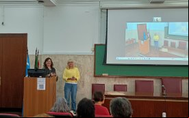 Fotografia mostra duas mulheres em pé. Valeska Pincovai, secretária de saúde do Sindicato usa blusa amarela e calça jeans