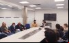 Imagem da reunião entre o Sindicat e a Ditec. A foto mostra uma sala onde estão reunidos, em uma mesa comprida e branca representantes do sindicato e funcionários